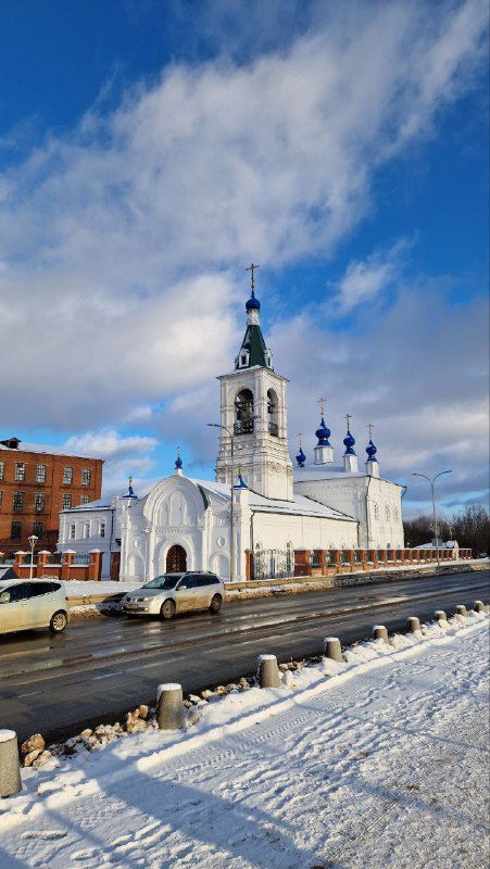 Классическая белая церковь в Шуе на фоне голубого неба: архитектура и зимний городской пейзаж у центральной улицы.