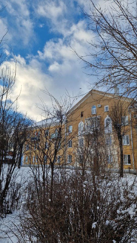 Улица Шуи зимой: жилые дома, заснеженные кусты и тёплый свет солнца, создающие уютный провинциальный вид города.