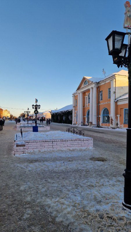 Пешеходная площадь в Шуе: открытое пространство, уличные фонари и фасады зданий, заметно подготовленные к праздничным мероприятиям.