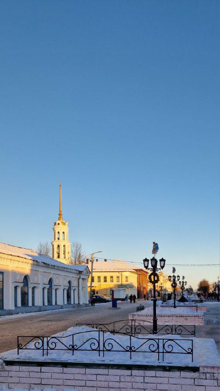 Длинная панорама центральной улицы Шуи с низкими зданиями и ясным зимним небом, ощущение тихого провинциального города.