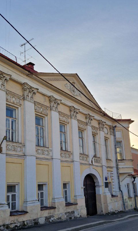 Классическая городская усадьба с портиком и колоннами, светлый фасад и историческая архитектура на пешеходном маршруте.