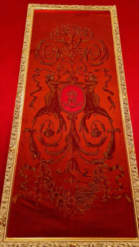 Красное панно с монограммой и декоративной вышивкой, выполненное для коронационных торжеств — часть исторического убранства театра.