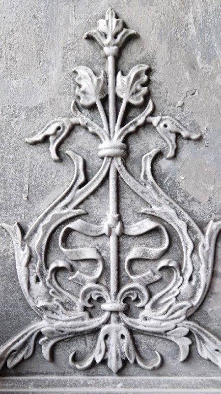 Декоративный рельеф на стене ресторана: светло-серый орнамент с растительными мотивами в крупном плане, элемент интерьерной отделки и стиля заведения.