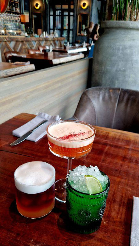 Три коктейля на столе: кофейно-сливочный Манго Сплит с манговой пеной, шоколадный коктейль и безалкогольный вариант — презентация напитков в барной подаче.