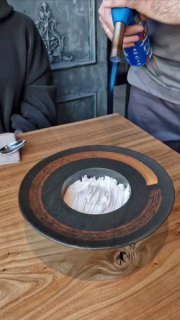 Сцена сервировки десерта с использованием газовой горелки: официант завершает приготовление блюда прямо у стола, процесс презентации в кадре.