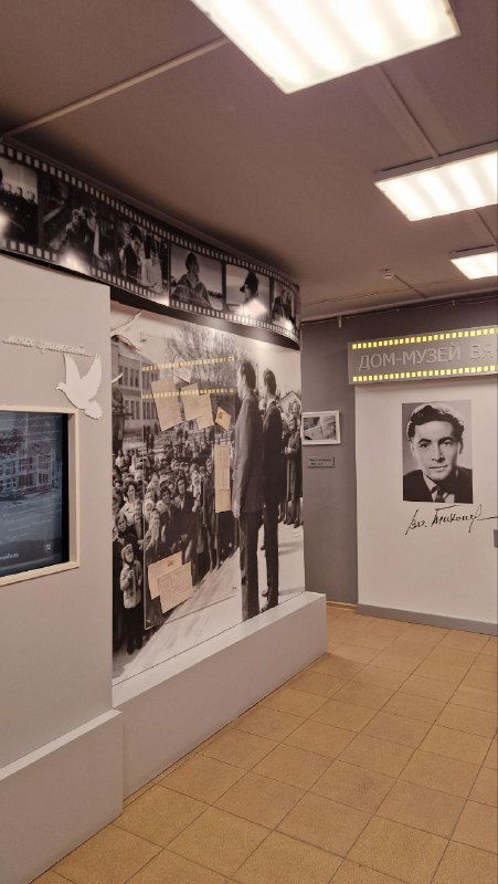 Чёрно‑белые архивные фотографии и экспозиционные панели в музее, портреты и кадры из жизни актёра на стенах выставочного зала.