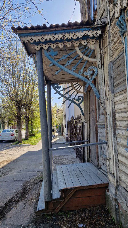 Деревянный крыльцо с резным козырьком, вид на характерную входную часть дома в районе Затьмачья — детали уличной деревянной архитектуры Твери.