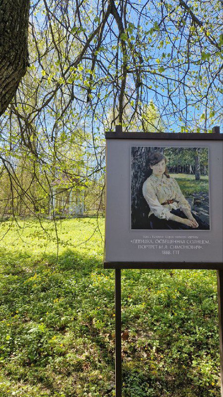 Информационный стенд с репродукцией картины Валентина Серова на зелёной лужайке усадьбы, весенний пейзаж и белые подсветки на фоне.