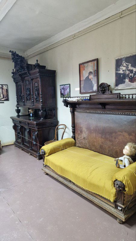 Интерьер музейного зала: антикварные шкафы и массивная кушетка, экспозиция с предметами быта и атмосферой провинциального музея усадьбы.