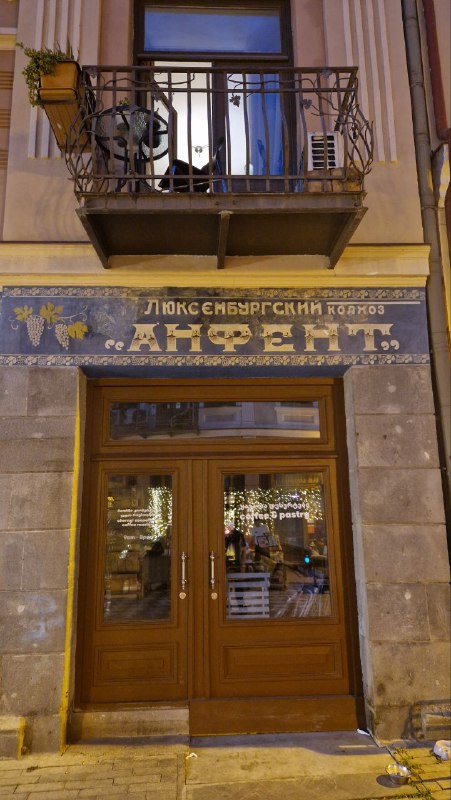 Вход в заведение с исторической вывеской «АНФЕНТ» над дверью — старая витрина и сохранившаяся надпись прошлого века.