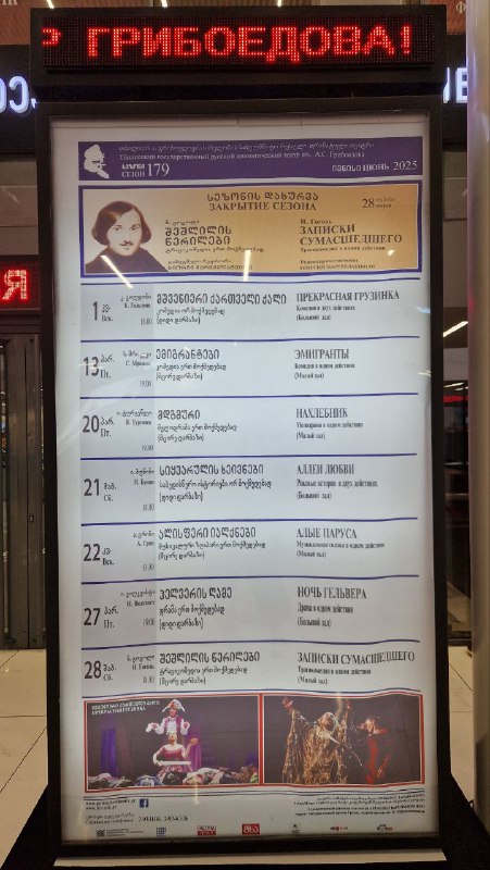 Информационная афиша с расписанием и постерами у входа в драмтеатр — городской кадр у Тбилисского русского драмтеатра имени Грибоедова.