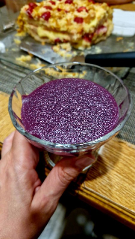 Пиала с густым фиолетовым пеламуши — крупный план традиционного грузинского десерта из виноградного сока и муки на деревянном столе.