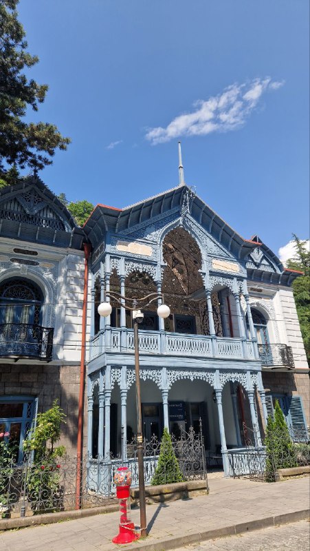 Историческое здание с резными элементами в Боржоми: деревянные и металлические детали фасада, типичная архитектура курортного городка.