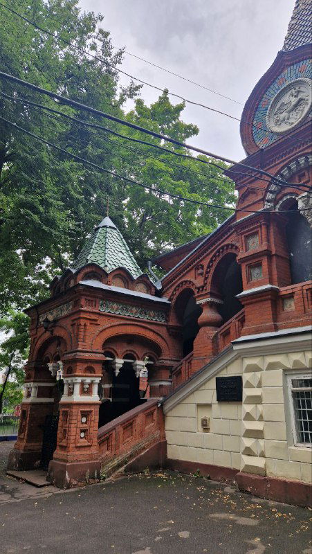 Парадная лестница и шатровое крыльцо терема: арочные своды, резные колонны и декоративные детали красного кирпича в псевдорусском стиле.