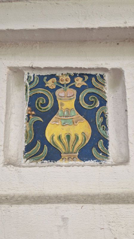 Керамический изразец с вазой и растительным орнаментом в нише белой стены — пример декоративных вставок в оформлении терема на Малой Грузинской.