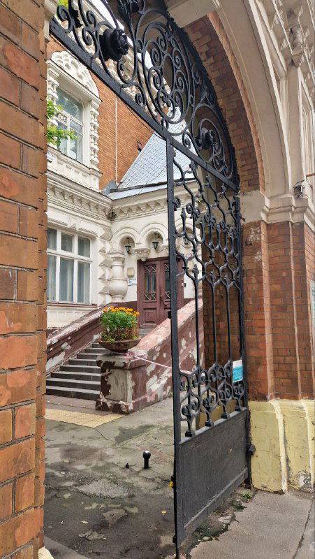 Ажурные кованые ворота во внутренний двор терема: металлический орнамент, открывающий вид на крыльцо и двор бывшего музейного комплекса Щукина.