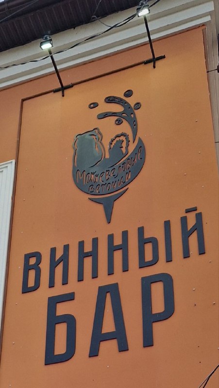 Оранжевая вывеска «Винный бар» на фасаде; городской гастрономический элемент и указание на локальные места для еды и вина в Ельце.