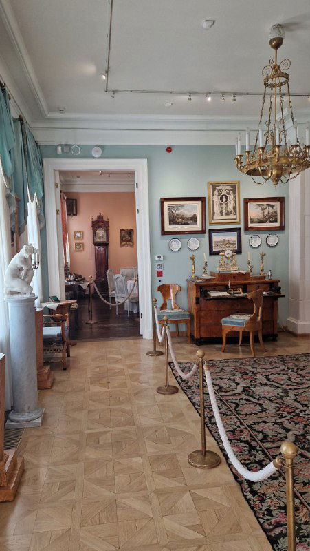 Широкий вид гостиной-музея с канделябрами, мебелью и предметами быта, отражающими литературную атмосферу кабинета хозяина.