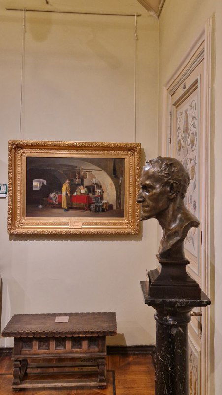 Экспозиция зала: картина в золочёной раме и бронзовый бюст на постаменте на фоне декорированной стены — экспонаты усадебной коллекции в Серпухове.