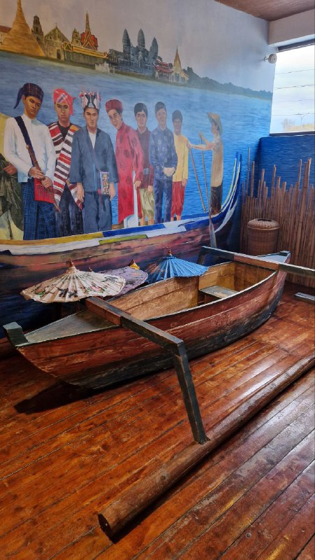 Интерьер с традиционными лодками и настенной росписью в одном из павильонов Этномира: музейная экспозиция с речным сюжетом и реквизитом.