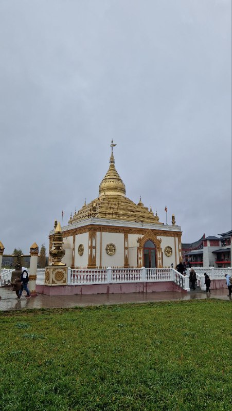 Пагода в стиле Швезигон на открытой территории Этномира: бело-золотая конструкция с куполом, ступенчатая база и зелёная лужайка вокруг.