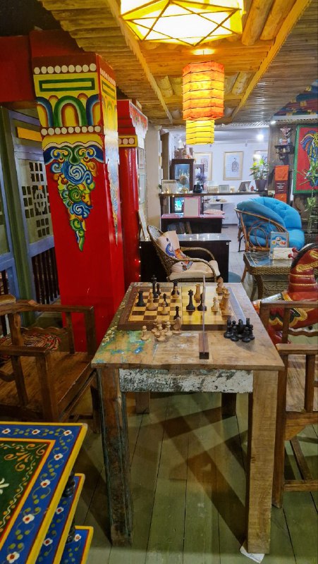 Кафе в индийском павильоне Этномира: столы с настольными играми, разноцветные лампы и насыщенный этнический декор вокруг посетительской зоны.