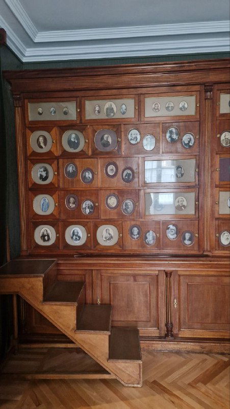 Большой библиотечный шкаф из красного дерева с множеством медальонов и книжными полками — интерьерная деталь, изготовленная по чертежам Немировича‑Данченко.