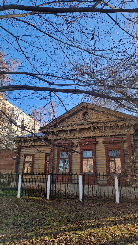 Низкое классическое здание в зелёной зоне — возможно дом управляющего фабрикой или особняк с колоннами и фасадом в историческом стиле.