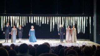 Сцена спектакля «Евгений Онегин» в Театре Маяковского: актёры на фоне большого ледяного декора с длинными сосульками, вид из зала и передняя труппа.