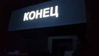 Тёмный кадр с крупной надписью «КОНЕЦ» на экране; финал спектакля показан резко и буквально, без метафор.