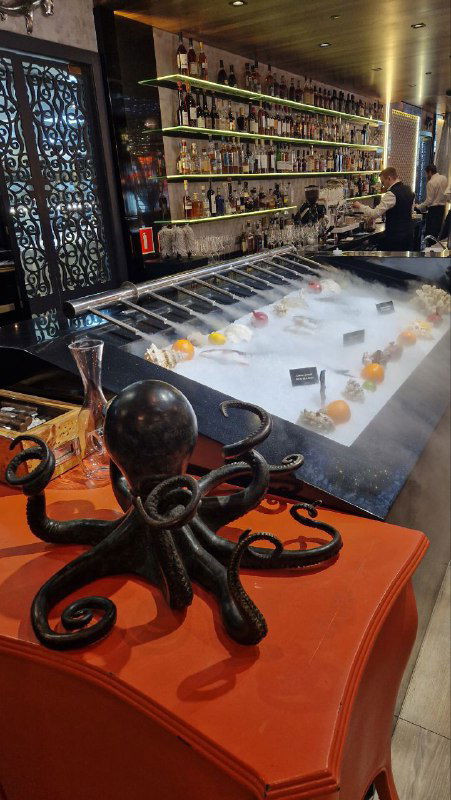 Барная стойка Peshi с ледяной подачей морепродуктов и акцентным декором в виде маленького декоративного осьминога на переднем плане.