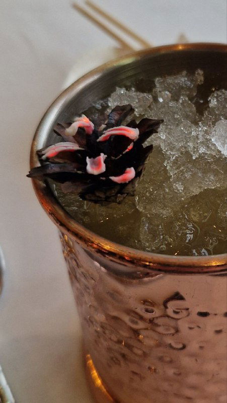 Коктейль на льду с цветочной или ягодной декорацией: деталь авторской подачи в Peshi, подчёркнутая кусочками льда и украшением.