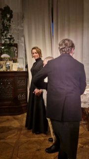 Кадр сценической постановки с несколькими актёрами в историческом интерьере: внимание к лицам, пластике и мелким реквизитам, подчёркивающим эпоху.