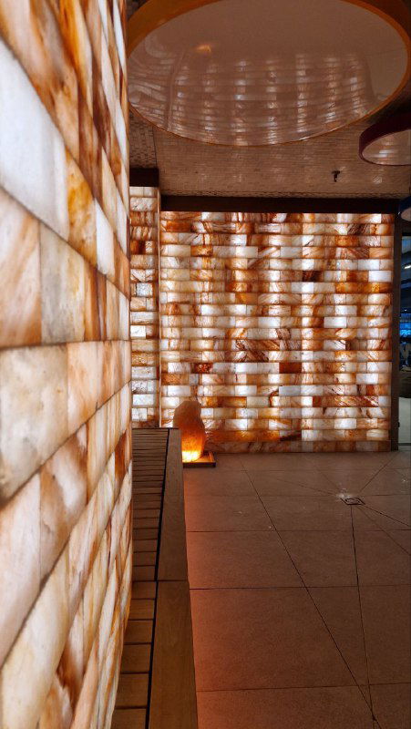 Солевая комната GREMM: подсвеченные блоки соли на стенах создают тёплую атмосферу и служат элементом оздоровительной зоны комплекса.