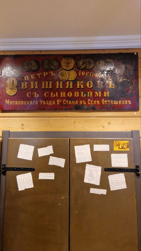 Старинная вывеска с фамилией Вишняковых на стене музея, рядом витрины и экспонаты жостовской росписи в музее Жостово.