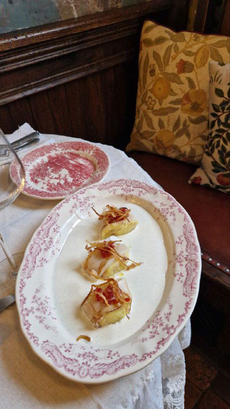 Тарелка с закуской: аккуратно выложенные маленькие порции на фарфоровой тарелке с узором, тонкая подача и художественная сервировка.