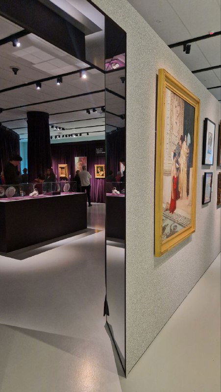 Коридор экспозиции с картинами и световыми решениями, вид на стену-стенд и общую планировку зала в Музее русского импрессионизма.