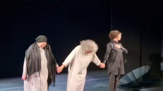 Актрисы держатся за руки в конце сцены: минималистичный реквизит, контрастные костюмы и эмоциональная сцена спектакля о судьбе и прощении.