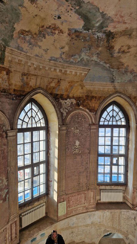 Окна и внутренние своды одной из башен: облупившаяся роспись, арочные окна с видом на зимний пейзаж и атмосферный интерьер с высоты.