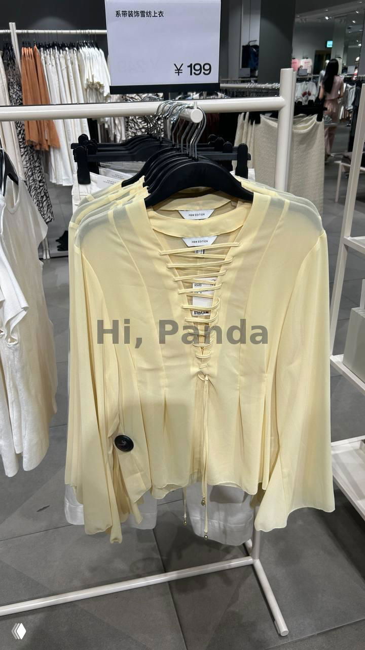 Жёлтая блузка H&M с декоративной шнуровкой и биркой на вешалке, указана цена ¥199 на табличке в магазине Mangrove Tree Sanya.