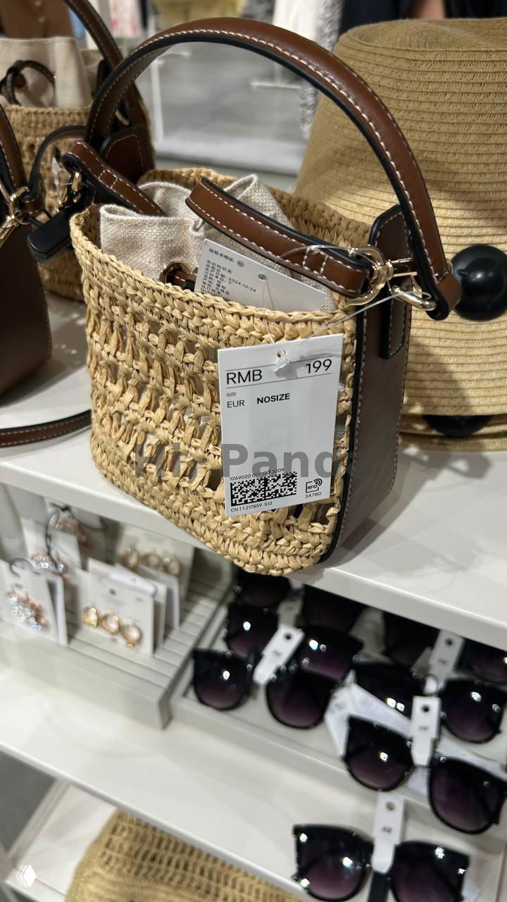 Плетёная сумка с кожаной ручкой и биркой RMB 199, выставлена на полке рядом с солнцезащитными очками в магазине H&M, ТЦ Mangrove Tree Sanya.