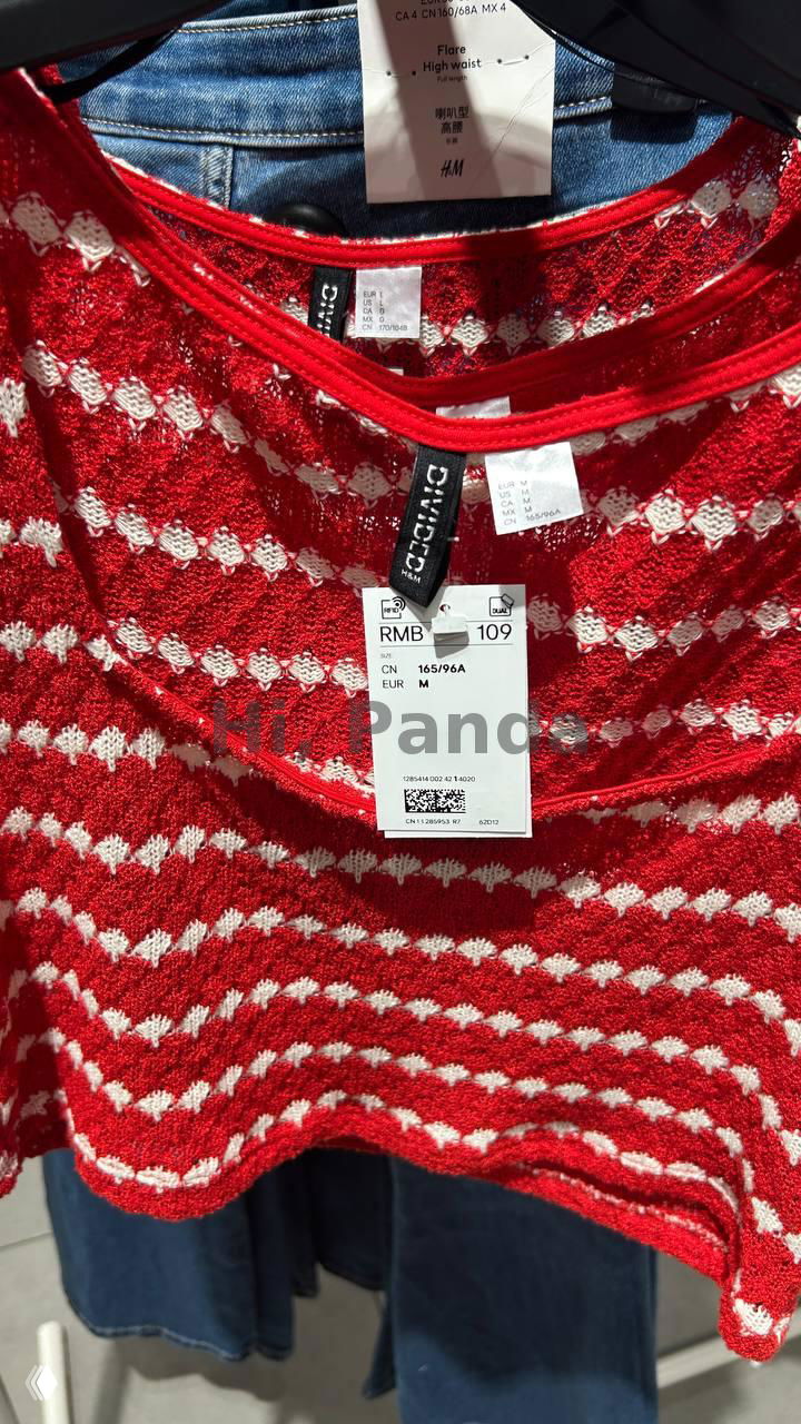 Крупный план красного вязаного топа с биркой H&M и ценой RMB 109; видно текстиль, яркую расцветку и бирку с QR-кодом на товаре в магазине.