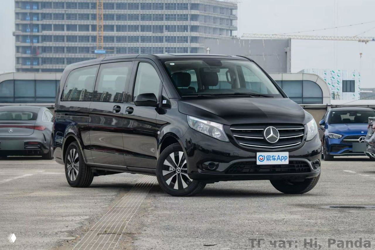 Чёрный пассажирский фургон класса Vito/аналог, вид спереди‑сбоку на парковке с городским фоном и отражениями на глянцевом кузове автомобиля.