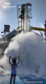 Большая падающая чаша и сильный водяной поток на фоне горок: эффектный момент спуска с большой чаши с брызгами и радующимися посетителями.