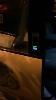 Кадр ночной улицы и открытой двери беспилотного такси с заметной графикой на боковой поверхности автомобиля, съёмка подчёркивает внешний вид и брендинг машины.