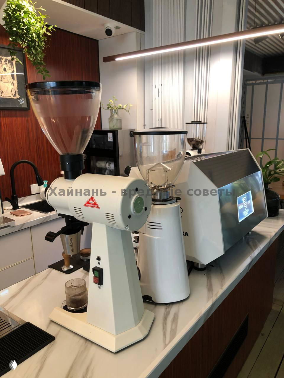 Кофемолка и рожковая кофемашина на барной стойке Cozy Coffee: рабочая зона бариста и оборудование для приготовления эспрессо и напитков.