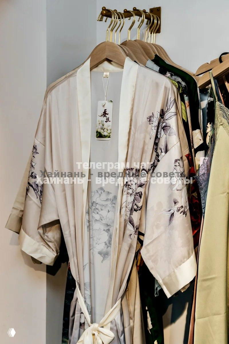 Одежда и халаты на вешалках в отделе магазина: тонкие ткани, летние наряды и несколько изделий в восточном стиле.