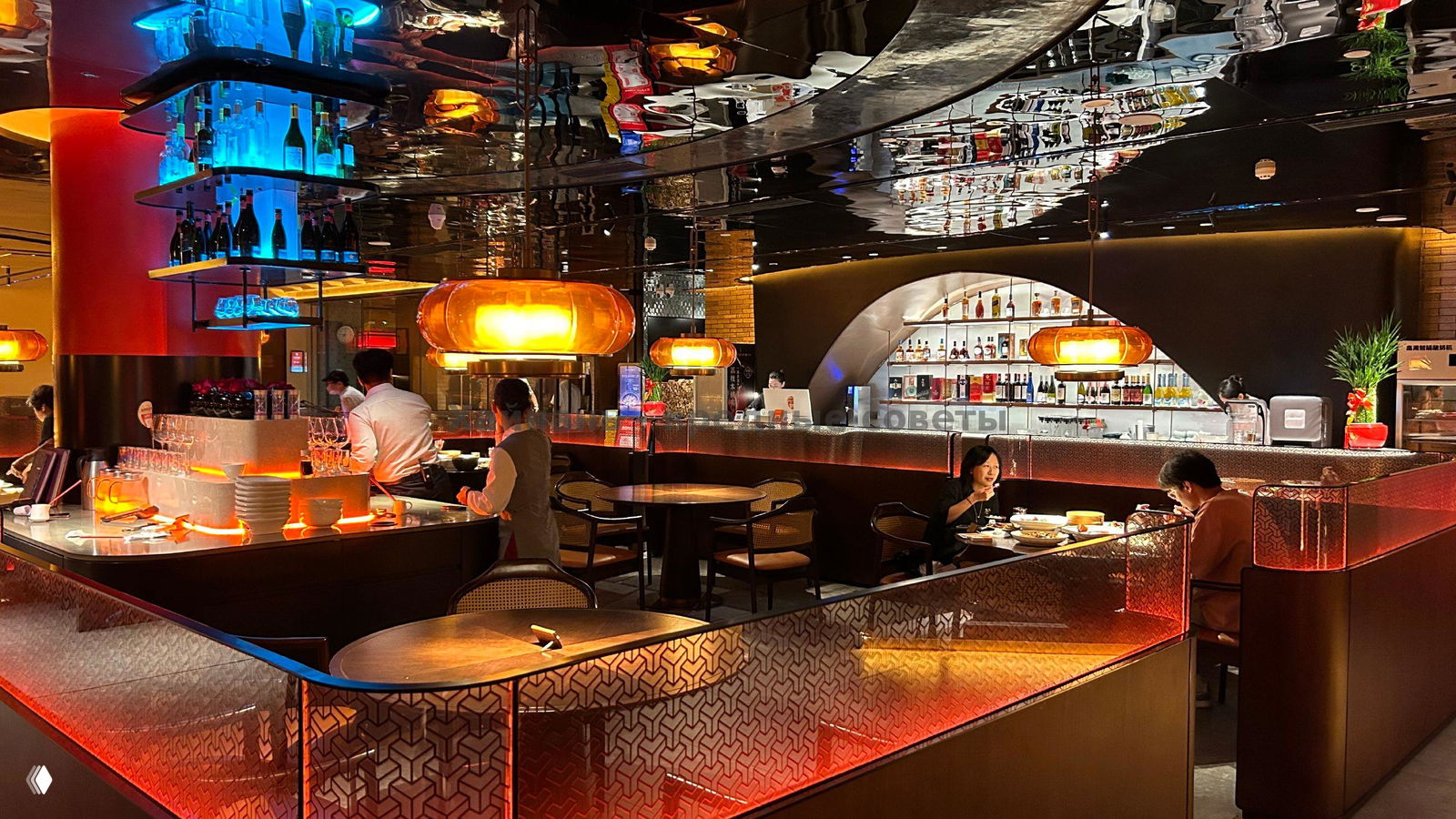 Широкий план зала ресторана 1981: барная зона, подвесные светильники и отражающий потолок создают эффектный интерьер.