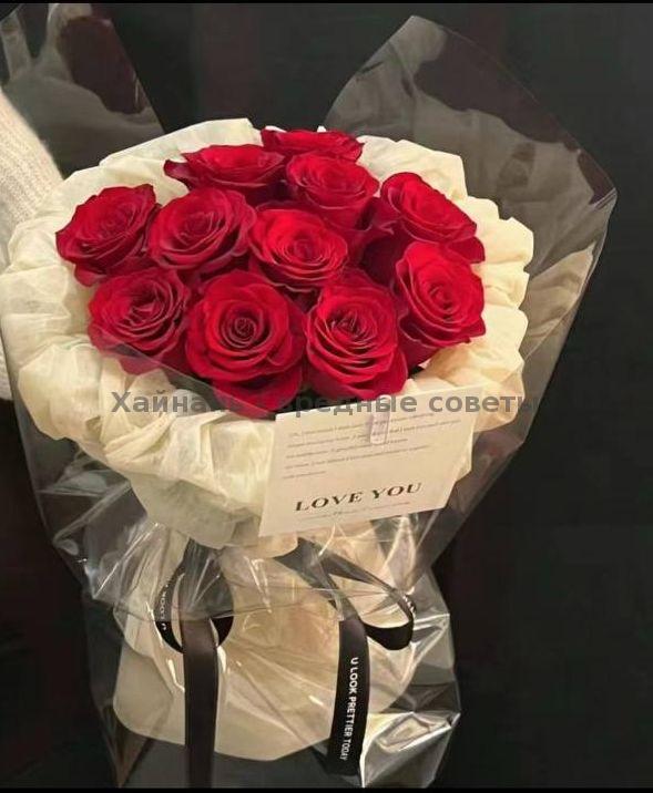 Классический букет из насыщенно-красных роз, плотно собранный и оформленный в светлую крафтовую и прозрачную бумагу с биркой «LOVE YOU», вид сверху.