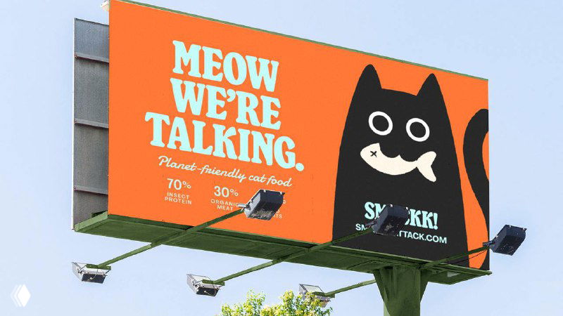 Наружная реклама Smackk на билборде: оранжевый фон, большой текст «MEOW WE'RE TALKING» и чёрная стилизованная морда кота, читаемая издалека.